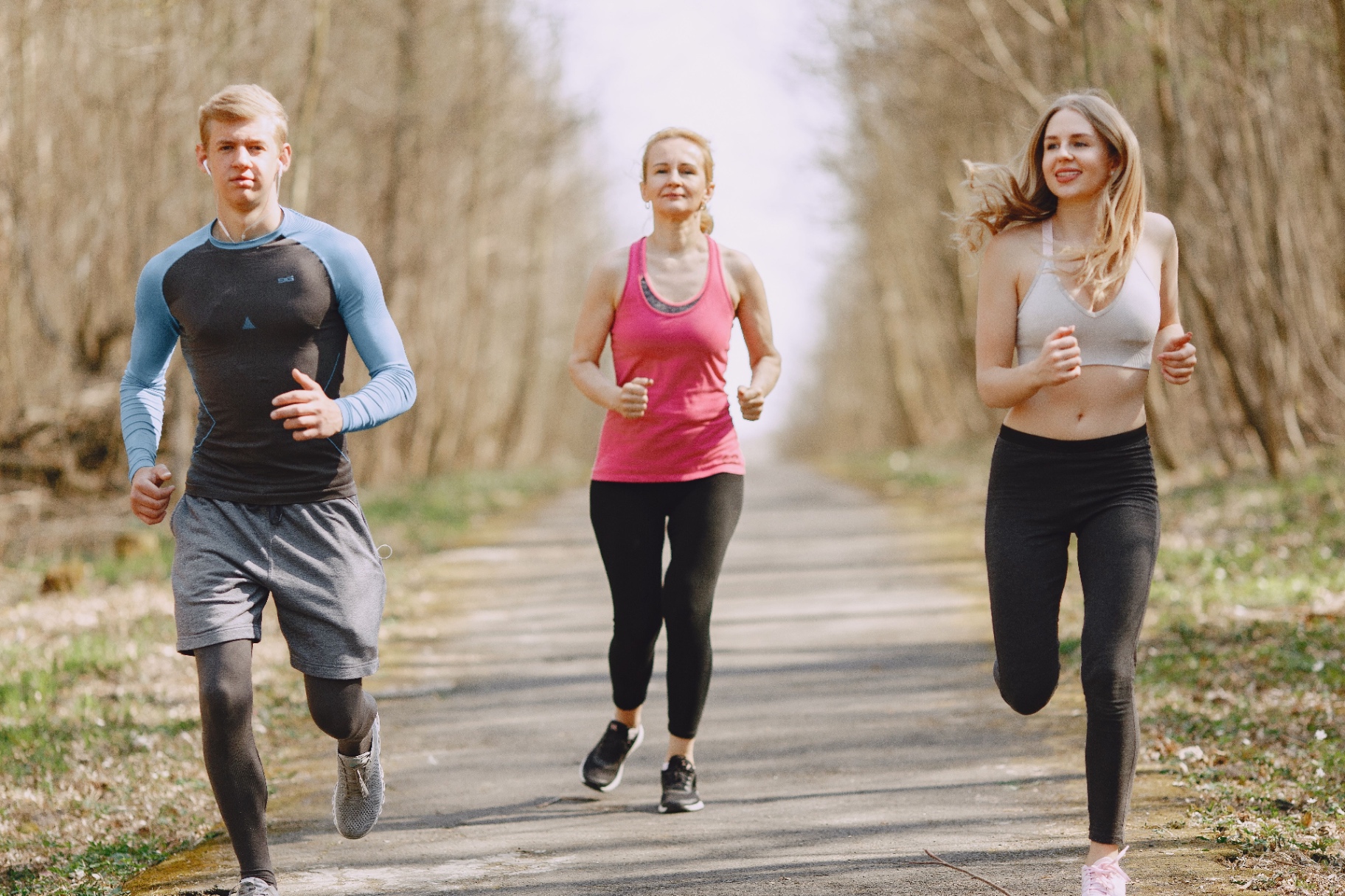 Three joggers running together on a path